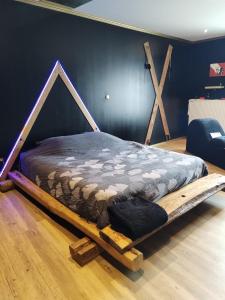 ein Bett mit einem Holzrahmen in einem Zimmer in der Unterkunft Love-room l'eden du Désir in Vecqueville