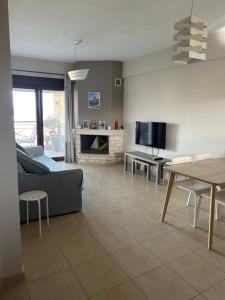 a living room with a couch and a tv at Stone House in Afytos in Afitos