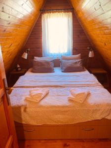 a bed in a wooden room with a window at Lulu Cottage in Žabljak
