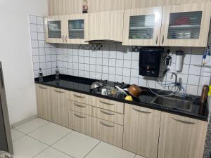 a kitchen with wooden cabinets and a sink at Aatmiya Heights in Vadodara