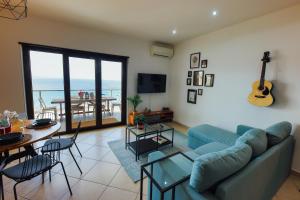 sala de estar con sofá y mesa con guitarra en Luxury Apartment, en Messina