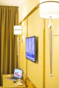 a room with a laptop and a tv on a wall at Hotel Teco in Milan