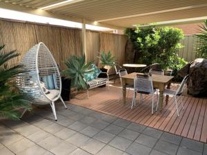 a patio with chairs and a table and a table and chairs at 83 Magnolia Avenue in Mildura