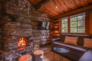 a living room with a fireplace in a log cabin at Salmenkelo, Ruka in Ruka
