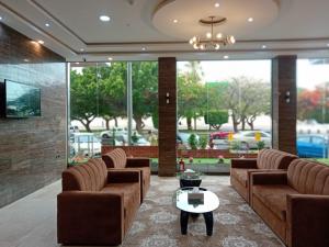 a lobby with couches and a table in a room at Nilufer AlHada Hotel - فندق نيلوفر الهدا in Taif