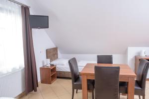 a dining room with a table and chairs and a bed at Willa Północna II in Karwia