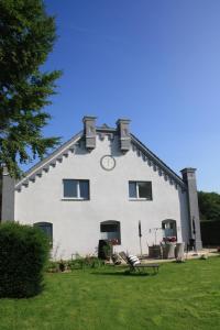 a large white house with a clock on the roof at Ferienwohnung Voerde-Götterswickerhamm-"die Perle am Niederrhein" in Götterswickerhamm