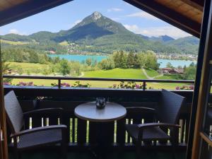 a table and chairs on a balcony with a view of a mountain at Haus Klaushofer in Fuschl am See