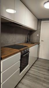 a kitchen with white cabinets and a stove at ALEJANDRO PLAYA Gandia 1 in Los Mártires