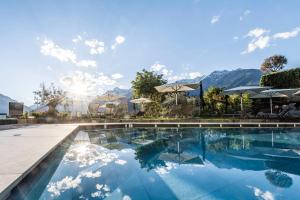 a swimming pool with mountains in the background at Schenna Resort in Schenna