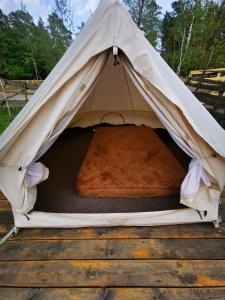 a beige tent with a bed in the middle at pole namiotowe Stajnia Kaliska in Łochów