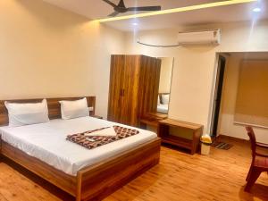 a bedroom with a large bed with a wooden floor at SV Banquets And Luxury Rooms in Farrukhnagar
