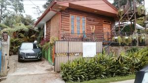 a car parked in front of a wooden house at 20/20 wood cabana in Nuwara Eliya