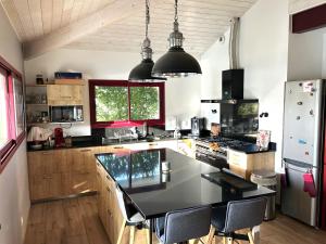 a kitchen with a black counter top in a room at Villa Lou Bercail HOURTIN - 10 personnes in Hourtin