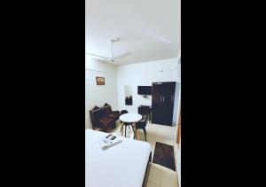 a kitchen and a living room with a table at Apsara Residency in Perintalmanna