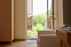 a living room with a view of a sliding glass door at Les chambres du Moulin in Arleux-du-Nord