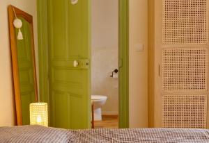 a bathroom with a green door and a toilet at Les chambres du Moulin in Arleux-du-Nord