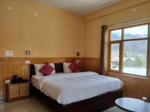 a bedroom with a large bed with a window at Hotel Spiti Heritage in Kaza +67 photos