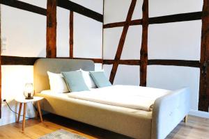 a bed with white sheets and blue pillows in a room at Altstadt Apartment II - Terrasse- Waschmaschine- Parkplatz in Wolfsburg