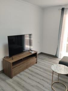 a living room with a flat screen tv and a table at ALEJANDRO PLAYA Gandia 1 in Los Mártires
