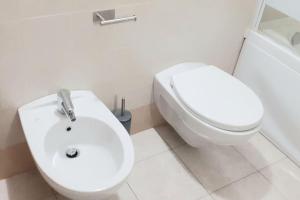a white bathroom with a toilet and a sink at Casa Olimpia 52 in Verona +10 photos