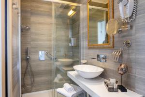 a bathroom with a sink and a mirror and a shower at Hotel Metropole in Santa Margherita Ligure