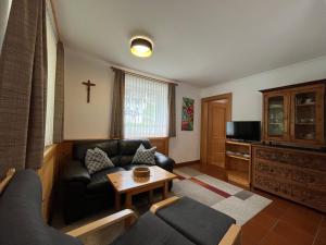 a living room with a couch and a table at Ferienwohnung Webhofer in Außervillgraten
