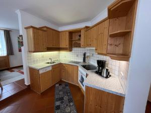 a kitchen with wooden cabinets and a sink at Ferienwohnung Webhofer in Außervillgraten