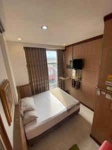 a small bedroom with a bed and a window at The Cabin Hotel in Yogyakarta