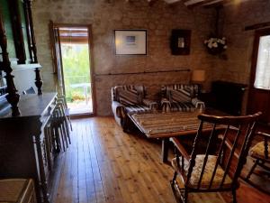 a living room with a couch and a table at El Desván del Campanero in Murillo de Gállego