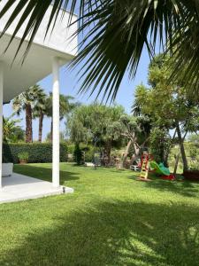 a yard with a playground and palm trees at Appartamento Da Maria in Caulonia Marina