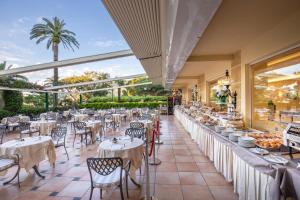 a restaurant with white tables and chairs and windows at Hotel Metropole in Santa Margherita Ligure