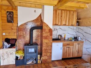 a kitchen with a wood stove in a room at Ljeljen koliba in Sokolac