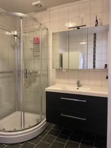 a bathroom with a shower and a sink and a glass shower at Apartment with free parking 350 m from the center of Ålesund private apartment in Ålesund