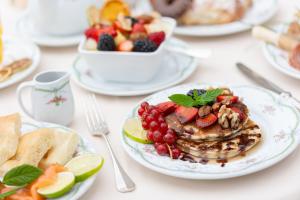 a table topped with plates of food with fruit at Hotel Metropole in Santa Margherita Ligure