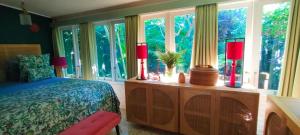 a bedroom with a bed and a large window at Rumah TONTON, Charming cottage in a pop-art atmosphere in Kubutambahan