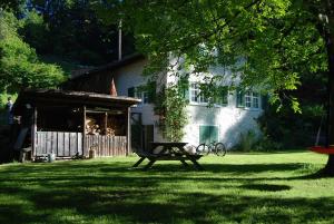a picnic table in front of a house at Bergbauernhaus an Wasserfall und Waldrand in Schwändi
