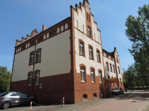 ein großes Backsteingebäude mit einem großen weißen Banner darauf in der Unterkunft Hotel Carl von Clausewitz in Burg bei Magdeburg
