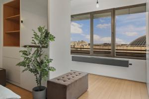 Una sala de estar con una gran ventana y un sofá. en RH Apartment - Opposite Bucharest Mall, Metro, Balcony - RH Living, en Bucarest
