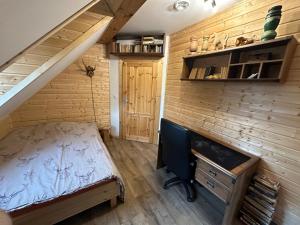 a bedroom in a tiny house with a bed and a desk at Bieszczady ClaraArt in Czarna