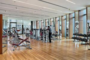 une salle de sport avec des tapis roulants et des appareils d'exercice dans un bâtiment dans l'établissement Downtown 2BR Skyline Views & Prime Dubai Stay Near Burj Khalifa, Mall, à Dubaï
