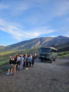 a group of people standing around a van on a dirt road at Casa Holiday Sea Etna Di Enza in Linguaglossa