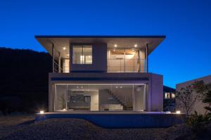 a house with glass windows at night at CHLOROBIANCO amami in Amami