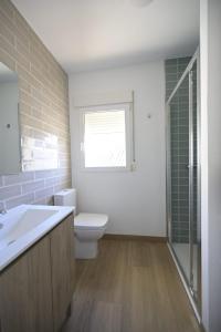 a bathroom with a toilet and a sink and a window at La placita in Zaragoza +20 photos