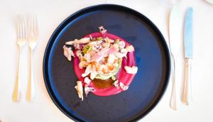 a blue plate with food on a table with silverware at Hotel Metropole in Santa Margherita Ligure