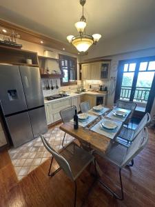 a kitchen with a table and chairs and a refrigerator at Thea Thalassa in Vourvourou