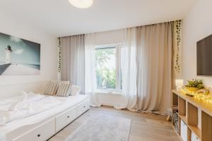 a white bedroom with a large bed and a window at Szabadi Pihenőház by BLTN in Siófok +42 photos