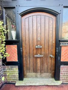 a wooden door on a building with a brick wall at Little Chelsea Garden Flat in Eastbourne