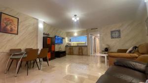salon z kanapą, stołem i krzesłami w obiekcie Apartamento Golf Beach w mieście Benalmádena