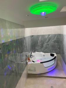 a bath tub in a room with a green ceiling at TRULLO AURORA BOREALE in Alberobello +43 photos